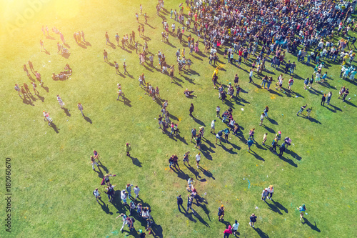 Top view of people in paint-stained  on the green grass