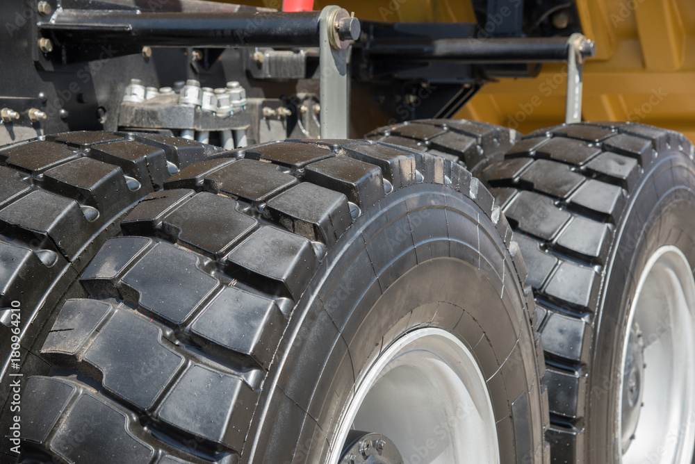 Some parts from a large car for transportation of ore called Belaz, black wheels, blue stairs and others. Some parts from a large car for transportation of ore called Belaz, black wheels, blue stairs and others.