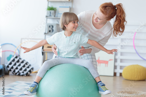 Physical therapist assisting little boy photo