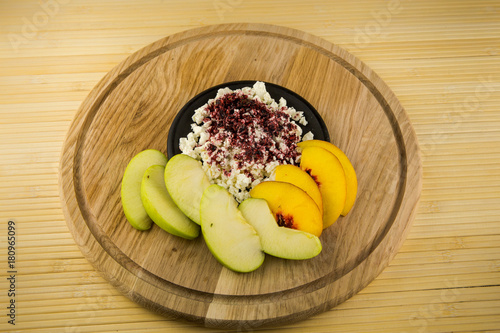 cottage cheese with acai powder decorated with sliced apple and peach