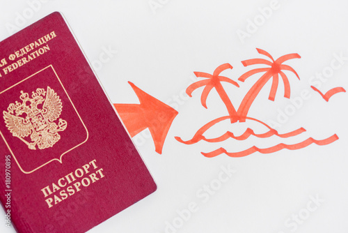 Russian parport lying on white paper with a painted arrow and an island with palm trees