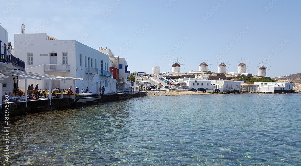 View of the famous windmills of Mykonos island from Little Venice restaurant View of the famous windmills of Mykonos island from Little Venice restaurant