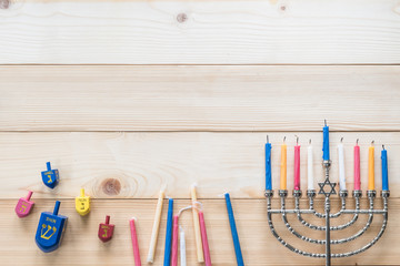 Hanukkah/ Chanukah Jewish holiday background with menorah (Judaism candelabra)  burned candles and traditional Dreidrel game toy on wood table backdrop