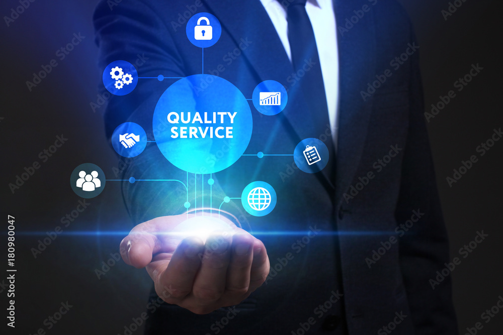Business, Technology, Internet and network concept. Young businessman working on a virtual screen of the future and sees the inscription: Quality service Business, Technology, Internet and network concept. Young businessman working on a virtual screen of the future and sees the inscription: Quality service
