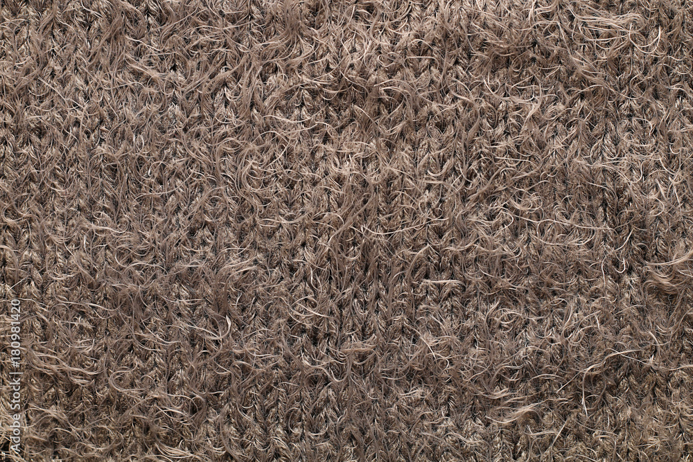 Texture of a fragment of a warm winter female soft fluffy brown sweater Texture of a fragment of a warm winter female soft fluffy brown sweater