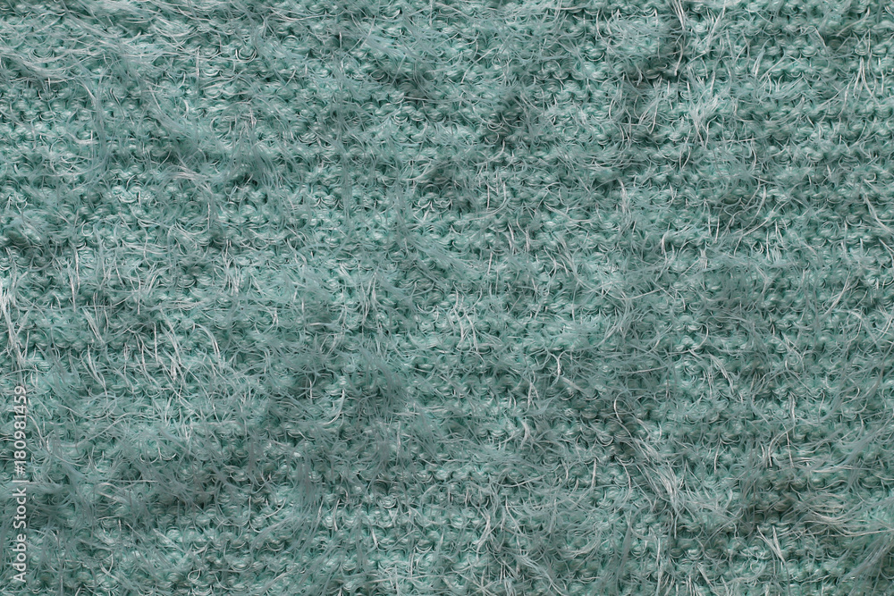 Texture of a fragment of a warm winter female soft fluffy blue sweater Texture of a fragment of a warm winter female soft fluffy blue sweater