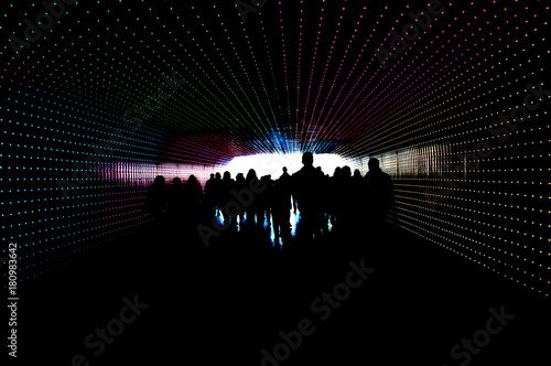group of young people in a tunnel with colored lights
