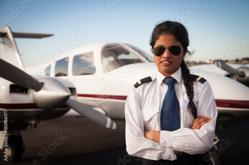 Fototapeta Female Pilot Standing in front of her Aircraft