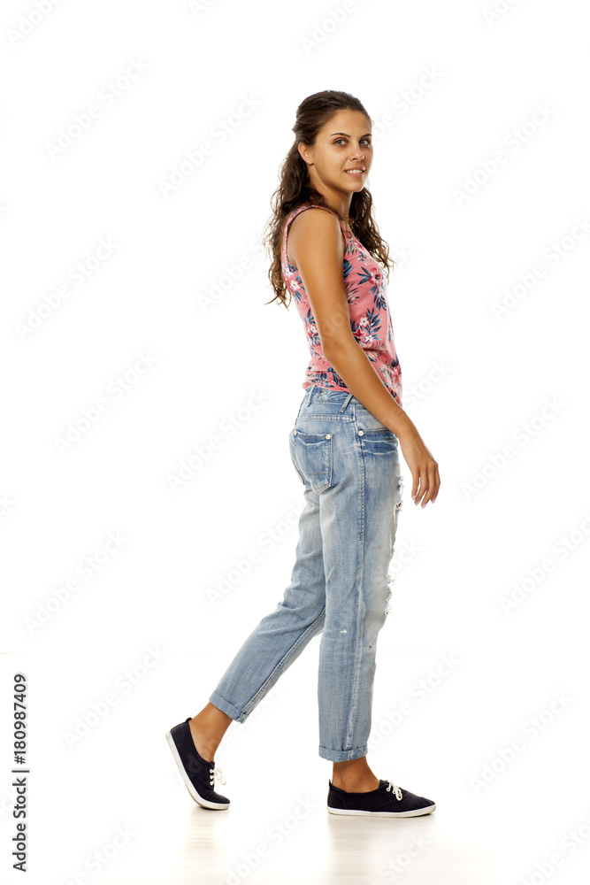 profile of young woman with torn jeans walking on white background profile of young woman with torn jeans walking on white background