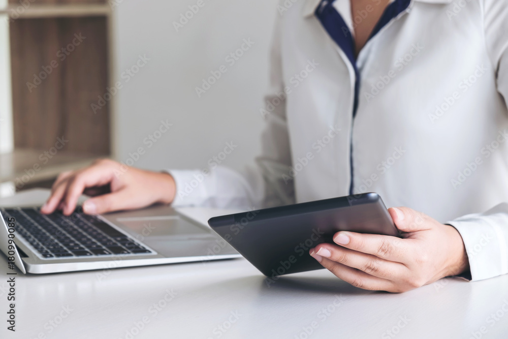 Business woman working and using laptop computer, digital tablet, business and technology concept Business woman working and using laptop computer, digital tablet, business and technology concept