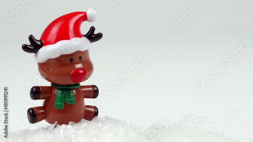 Cute Rudolph the red-nosed reindeer bobblehead poppet dancing happy in the snow photo