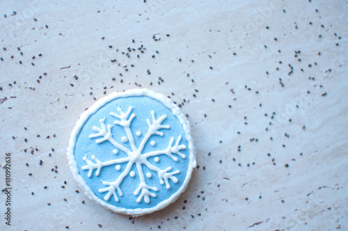 A Christmas gingerbread cookie in the shape of a blue round snowflake. Top view, flat lay, copy space.