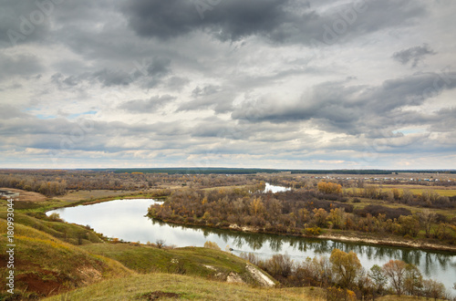 Autumn landscape on the hills of the River Don. View of the pond on a background of cloudy sky .. © olgapkurguzova