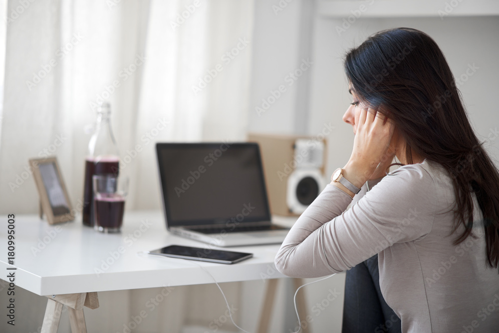 Woman sitting in home office and using tablet Woman sitting in home office and using tablet