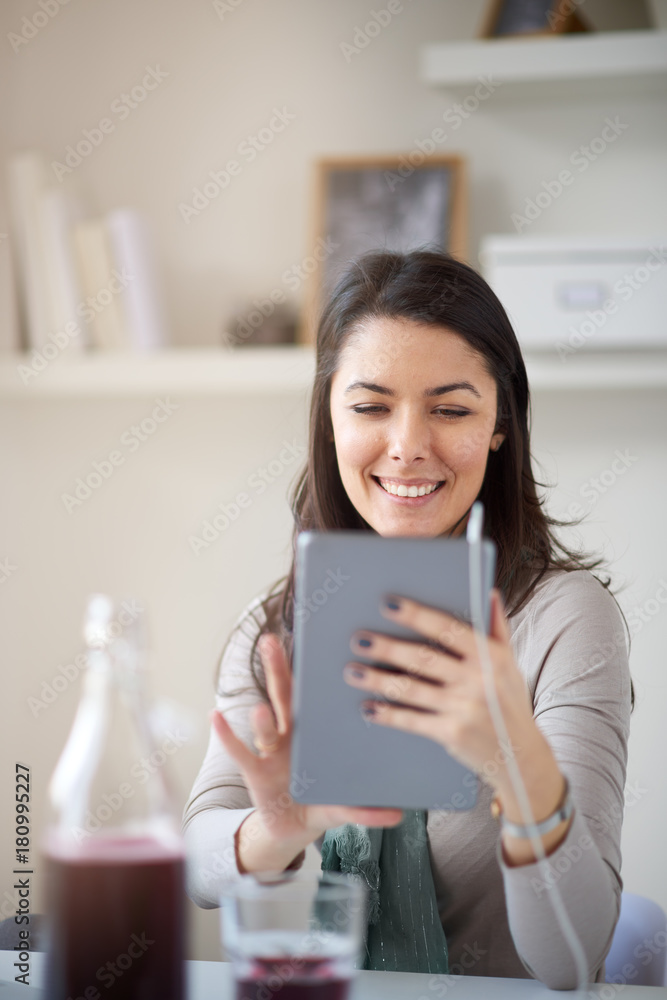 Woman sitting in home office and using tablet Woman sitting in home office and using tablet