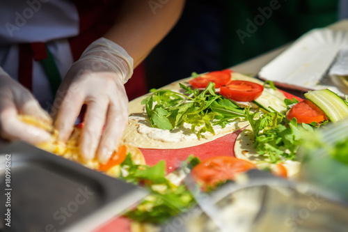 Close-up of hands of cook in gloves preparing fajitas, tortilla. Healthy fresh food. Concept national food, healthy fast food, summer paty
