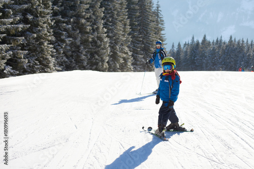 Cute little boy, skiing happily in Austrian ski resort in the mountains