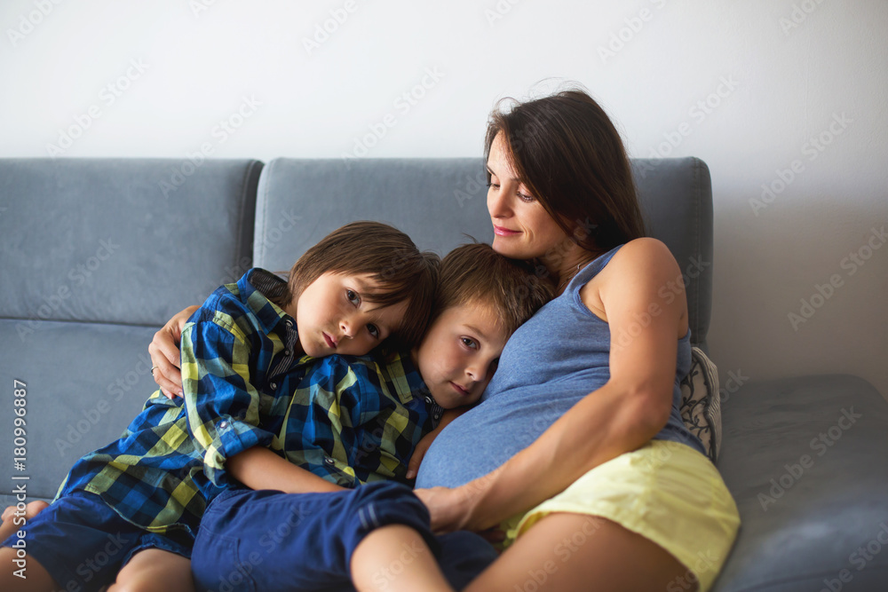 Portrait of beautiful pregnant mother, hugging her children