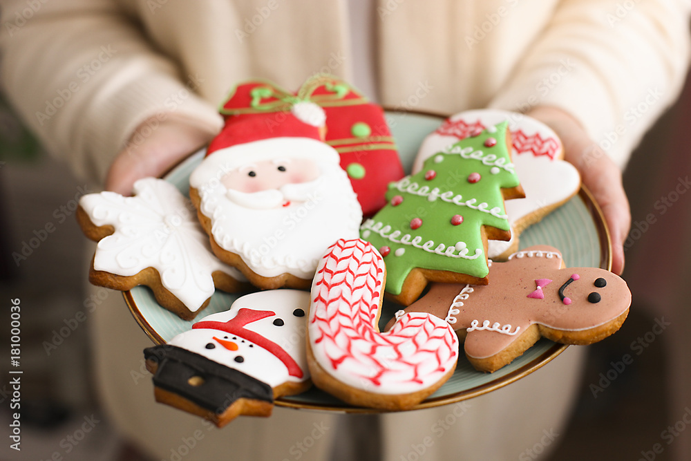 Christmas gingerbread cookies on the plate in the women's hands