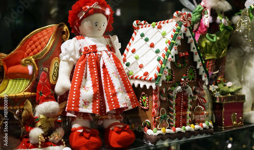 Christmas decorations in a toy shop window including traditional red ragdoll and Gingerbread house