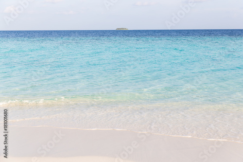 clear ocean water with island in the distance