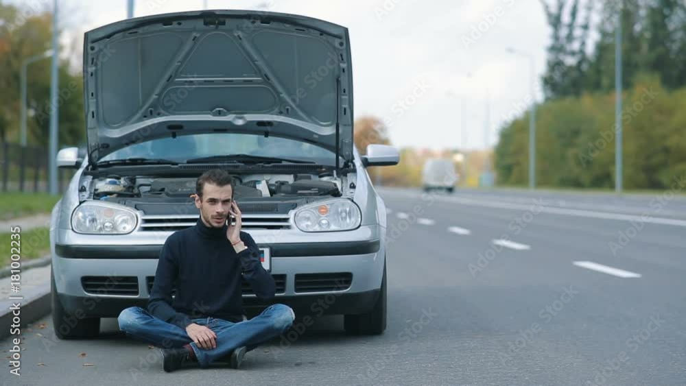 Man siitting on the road with broken Man siitting on the road with broken