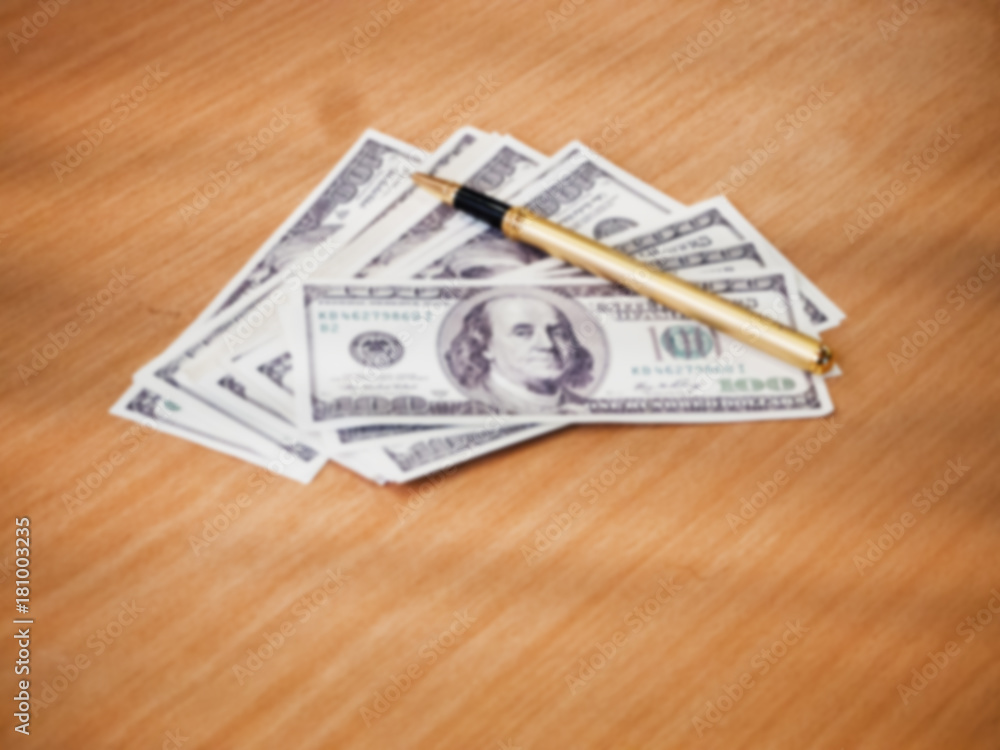 The blurry light design background of Us dollars and pen on wooden desk, The blurry light design background of Us dollars and pen on wooden desk,