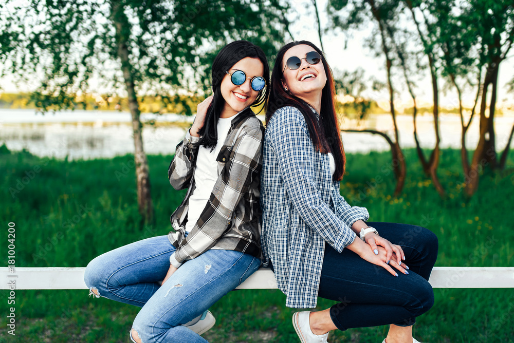 Two pretty brunette girls talking outdoor in the park Two pretty brunette girls talking outdoor in the park