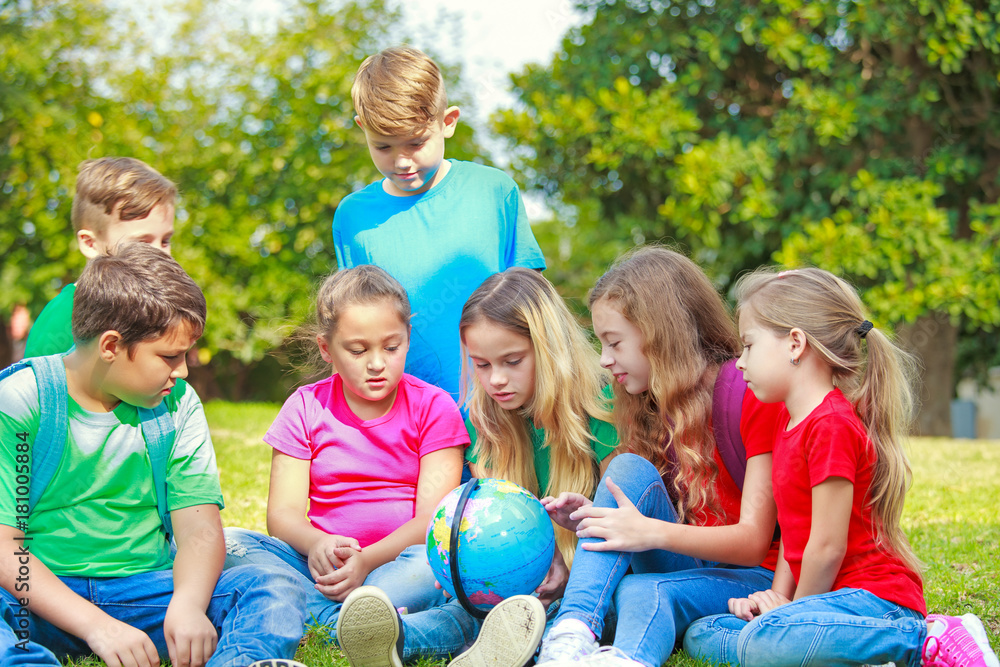 Children with a globe are learning geography at the park Children with a globe are learning geography at the park
