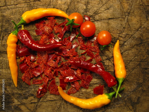 Still life of hot chili pepper, tomatoes on a old wood background