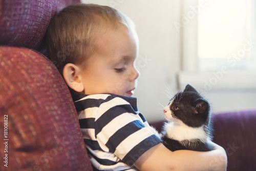 Little boy with kitten indoors taking good time
