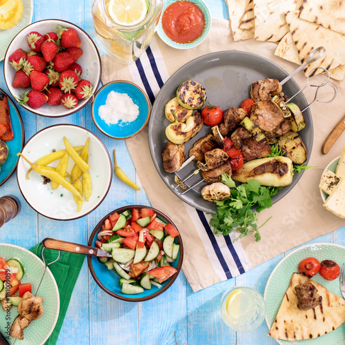 Shish kebab, various grilled vegetables, salad, lemonade, strawberries and snacks