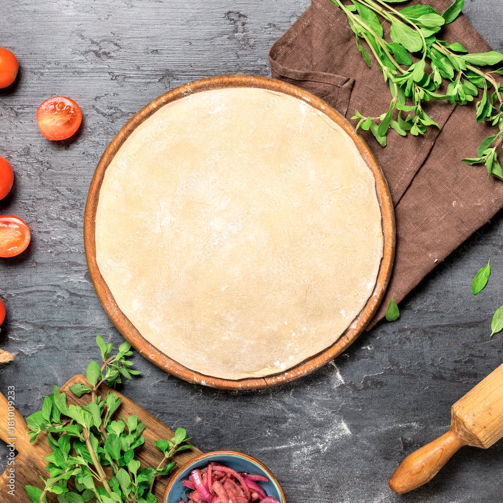 Raw pizza dough with set ingredients for cooking vegetarian pizza Raw pizza dough with set ingredients for cooking vegetarian pizza