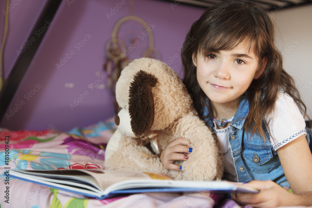 7 years old girl reading a book on bed Stock Photo Adobe Stock