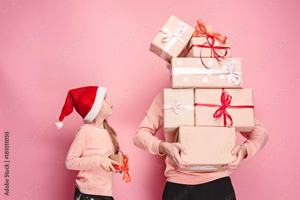 Fotografie Portrait of a surprised little girl with her father holding a Christmas present