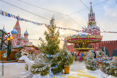 View of Kremlin and Cathedral of St. Basil at the Red Square decorated for New Year and Christmas holidays in winter at sunset, Moscow, Russia.