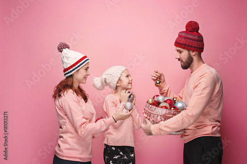 Father and mother give gifts to little daughter at studio