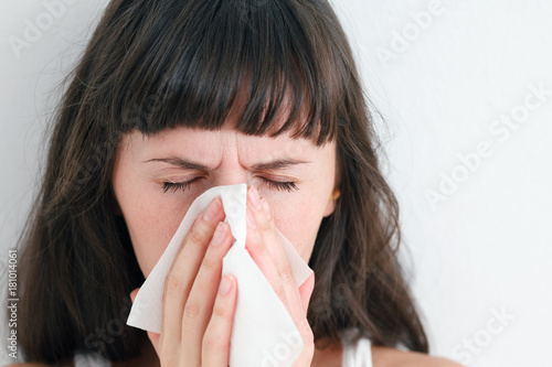 Woman cleaning her nose with a napkin