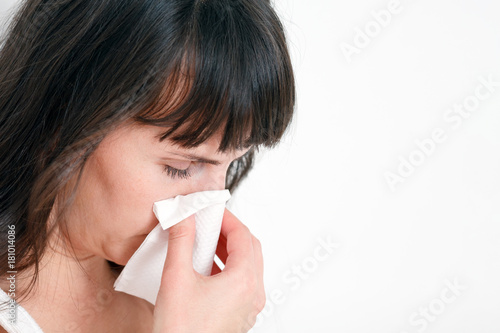 Woman cleaning her nose with a napkin