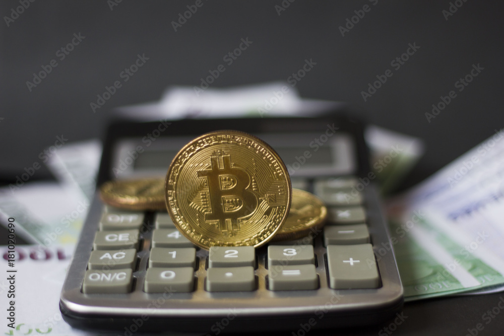 Golden bitcoins and banknotes Euro on a calculator on a black background. the new virtual money Golden bitcoins and banknotes Euro on a calculator on a black background. the new virtual money