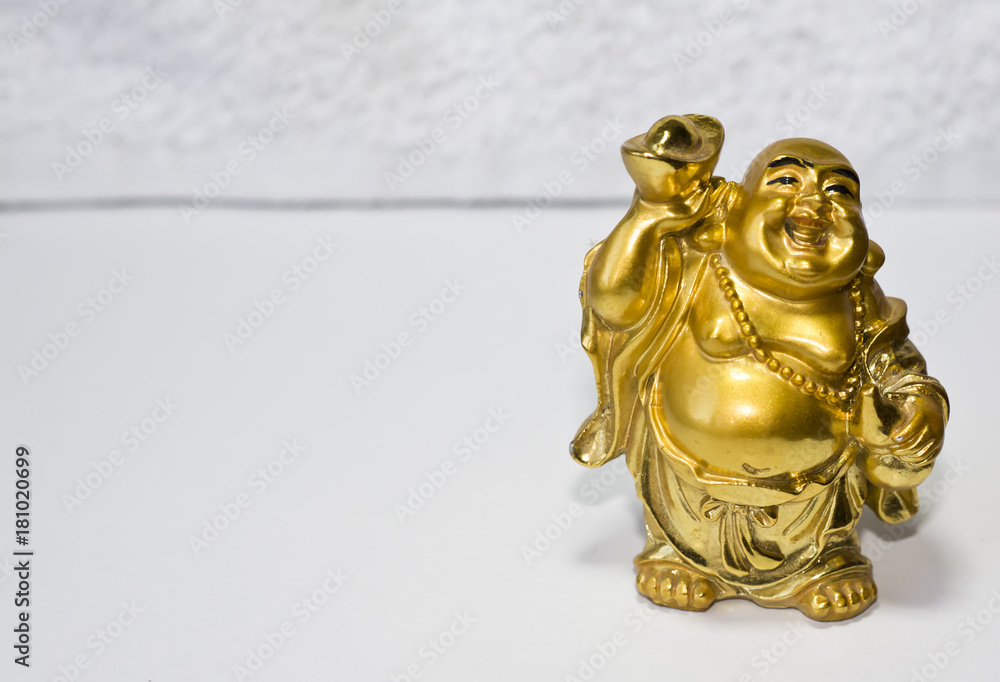 A statuette of a golden buddha. God Hotei is a laughing buddha.