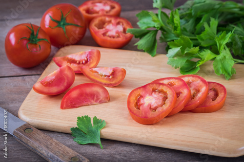 Tomato sliced on wooden cutting board