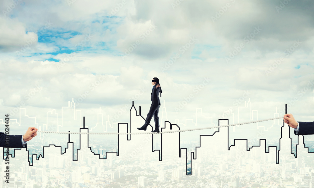 Business concept of risk support and assistance with man balancing on rope Business concept of risk support and assistance with man balancing on rope