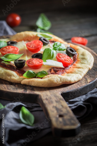 Homemade pizza with tomatoes, basil and cheese