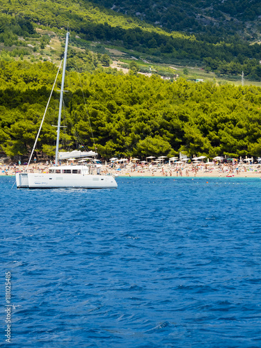 Katamaran vor dem Strand Zlatni rat oder Goldenes Horn, hinten die Insel Hvar, Bol, Insel Brač, Dalmatien, Kroatien,