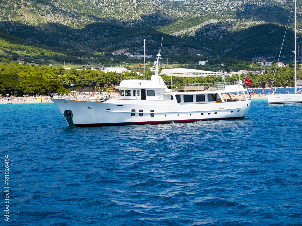 Alte Motoryacht vor dem Strand Zlatni rat oder Goldenes Horn, hinten die Insel Hvar, Bol, Insel Brač, Dalmatien, Kroatien,