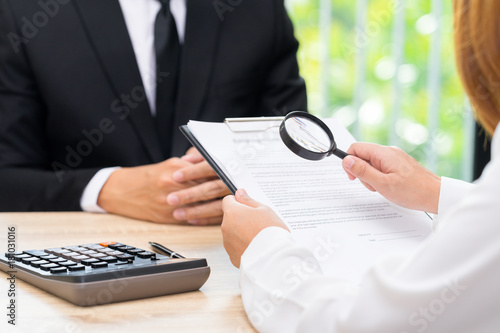 Woman inspects approved loan contract with bank seller.