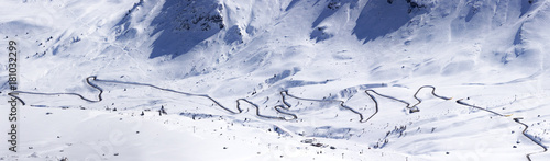 Panoramic view from Piz Boe towards Passo Pordoi, Sella Ronda slopes with skiers and ski lifts, local road cutting the picture in half