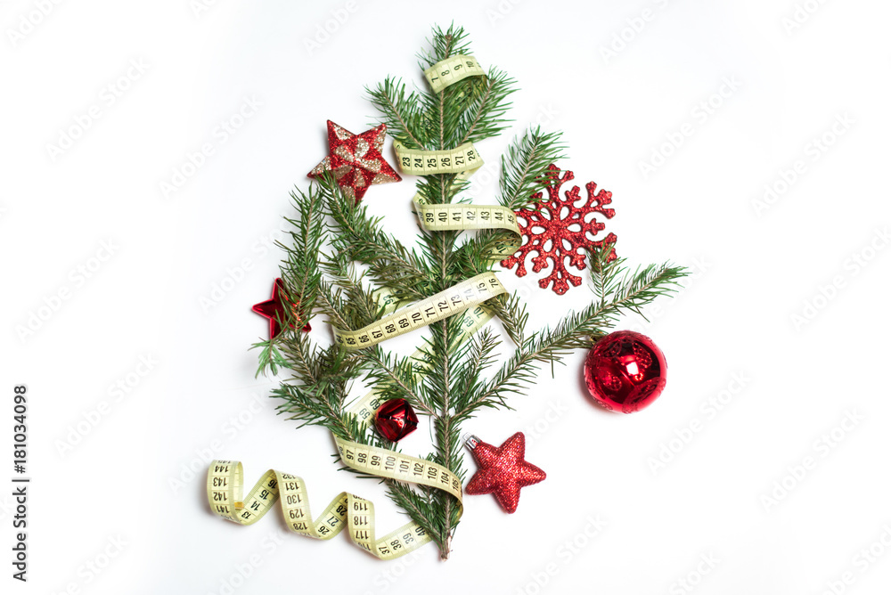 Fir branch (christmas tree) with tailor's meter and red new year balls isolated on white background Fir branch (christmas tree) with tailor's meter and red new year balls isolated on white background