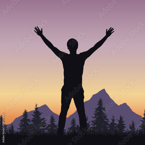 Realistic silhouette of a man welcoming sunrise in a mountain landscape with a forest